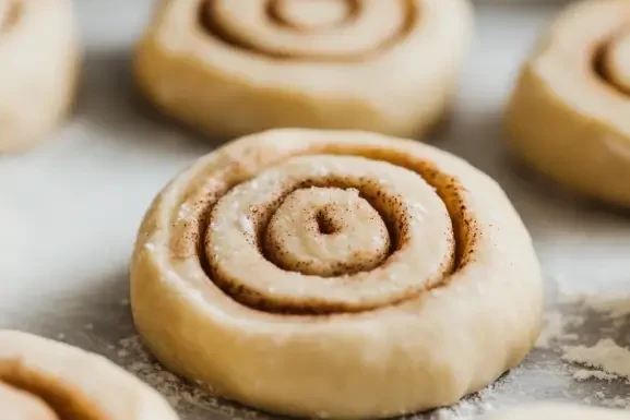 Unbaked cinnamon rolls arranged on a tray, made with sourdough discard